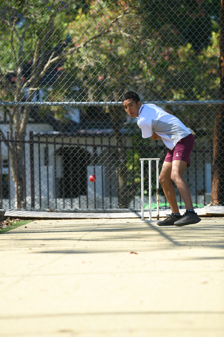 student playing cricket